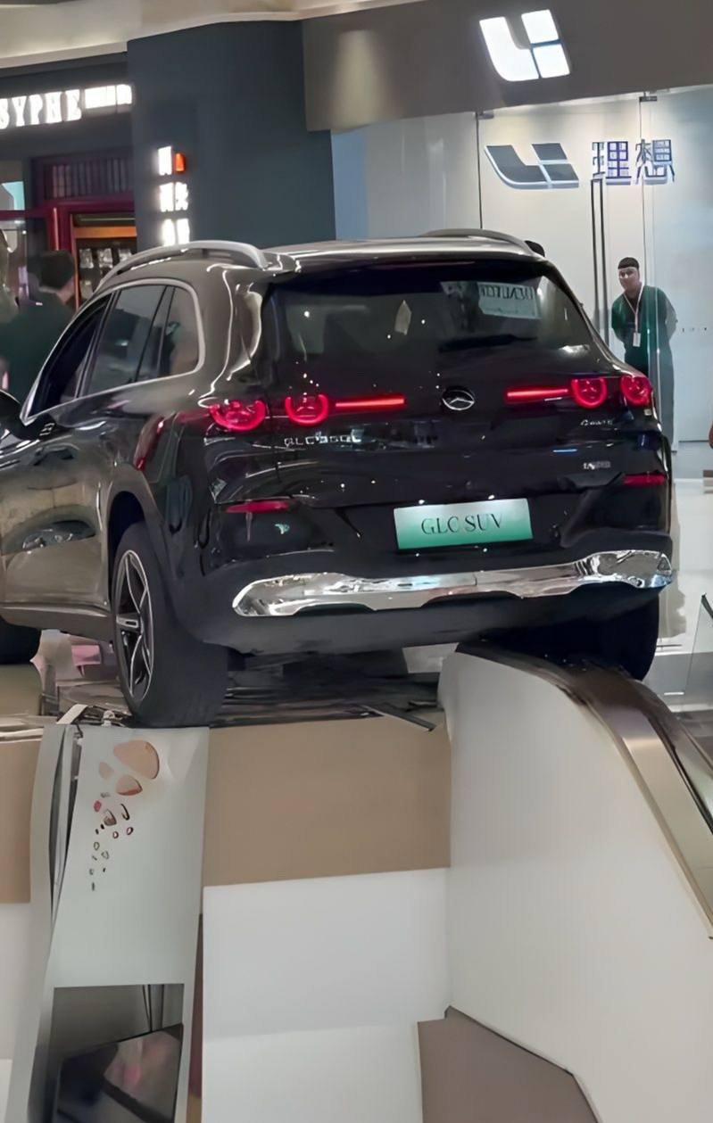 邯郸美乐城商场奔驰展车后撤失控撞碎扶梯护栏导致车辆半空悬挂