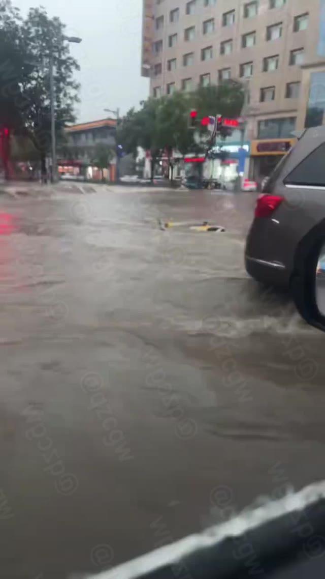 山西大同浑源县城遭遇突发强降雨导致街道积水成河并冲倒行人