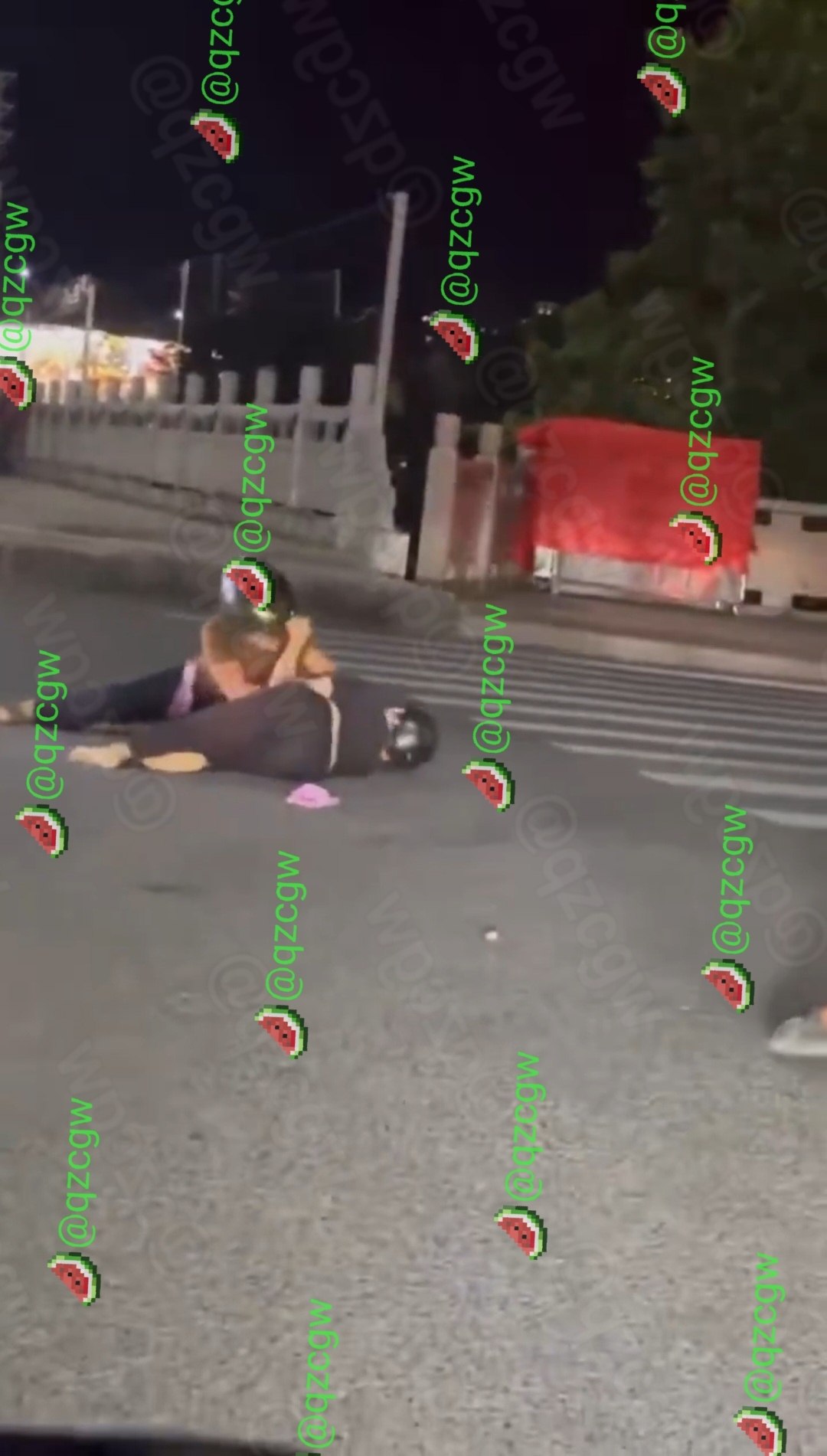 深夜街头两名戴头盔女子激烈互殴导致电动车倒地路人围观不劝架