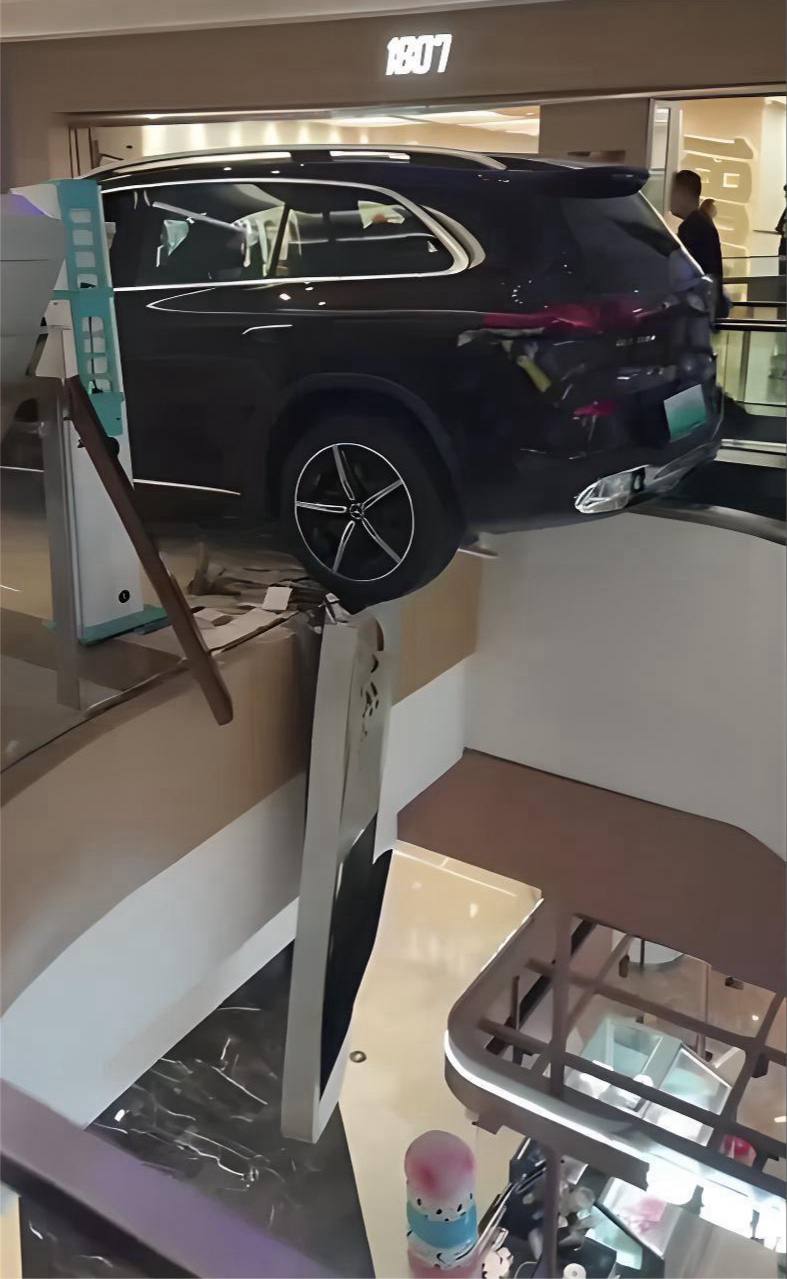 邯郸美乐城商场奔驰展车后撤失控撞碎扶梯护栏导致车辆半空悬挂