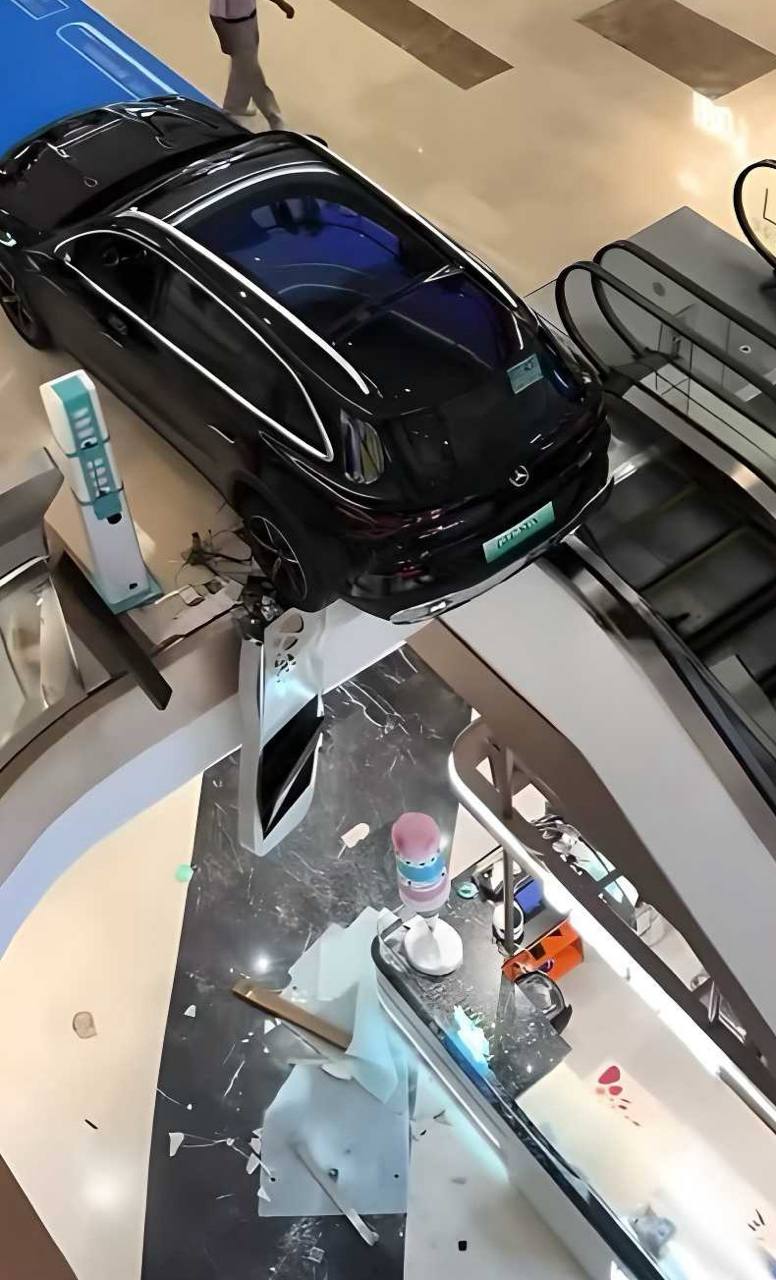 邯郸美乐城商场奔驰展车后撤失控撞碎扶梯护栏导致车辆半空悬挂